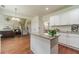 Stylish kitchen island with granite countertops that opens up to the living room and staircase at 2479 Mitford Ct, Dacula, GA 30019