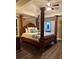 Opulent bedroom with a four-poster bed, tray ceiling, and access to the en-suite bathroom at 2479 Mitford Ct, Dacula, GA 30019