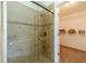 Shower with glass doors and tile surround, with access to the walk-in closet, shelving and carpeted floor at 2479 Mitford Ct, Dacula, GA 30019