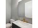 Modern powder room featuring gray walls, gold accents, and sleek fixtures at 522 Hargrove Ln, Decatur, GA 30030