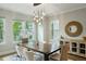 Well-lit dining area boasts a modern chandelier, round mirror, and stylish decor with hardwood floors at 522 Hargrove Ln, Decatur, GA 30030