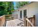 Wooden back deck leading to a door, surrounded by verdant greenery, offering a tranquil outdoor space at 5971 Dogwood Se Dr, Acworth, GA 30102