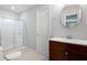 Well-lit bathroom featuring a vanity with a round mirror and a sliding glass-door shower, providing a clean functional design at 5971 Dogwood Se Dr, Acworth, GA 30102