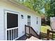Exterior detail showcasing a wood door, and wooden steps, accented by a green yard and trees at 5971 Dogwood Se Dr, Acworth, GA 30102
