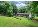 Expansive backyard with a well-manicured lawn, mature trees, and a charming outdoor seating area at 609 Hearth Pl, Lawrenceville, GA 30043