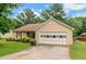 Charming single-story home with a tan siding, a driveway, an attached garage, and a well-manicured lawn at 9550 Canvasback Ct, Jonesboro, GA 30238