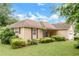 Well-maintained single-story home featuring tan siding, red shutters, an attached garage, and lush landscaping at 9550 Canvasback Ct, Jonesboro, GA 30238