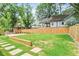 Spacious backyard featuring a lush lawn, wooden fence, and walkway stones leading to the house at 1253 Lucile Sw Ave, Atlanta, GA 30310