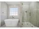 Elegant bathroom with a freestanding tub, glass shower, and large window, offering a luxurious feel at 1253 Lucile Sw Ave, Atlanta, GA 30310