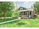 Well-kept home featuring a cozy porch and lush front yard with mature trees at 1253 Lucile Sw Ave, Atlanta, GA 30310