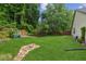 Spacious backyard with lush lawn, mature trees, and beautiful landscaping, perfect for outdoor enjoyment at 2277 Lazy Days Rd, Dacula, GA 30019