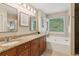 Bright bathroom featuring double vanities, granite countertop, tub, and natural light at 2277 Lazy Days Rd, Dacula, GA 30019