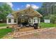 Covered outdoor patio has outdoor seating, a table, grill, and natural landscaping at 2277 Lazy Days Rd, Dacula, GA 30019