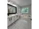 Luxurious bathroom featuring double vanity, a soaking tub, and marble countertops at 2720 Thornbury Way, Atlanta, GA 30349