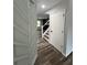 Inviting hallway featuring modern wood-look flooring, and staircase with black railings at 2720 Thornbury Way, Atlanta, GA 30349