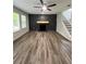 Modern living room featuring sleek wood floors, a fireplace with decorative molding, and a contemporary ceiling fan at 2720 Thornbury Way, Atlanta, GA 30349