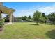 Beautifully landscaped backyard showcasing a spacious lawn with mature trees and a covered patio at 585 Lawton Bridge Sw Rd, Smyrna, GA 30082