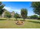 Landscaped backyard with stone fire pit, manicured lawn, trees and view of the rear of the house at 585 Lawton Bridge Sw Rd, Smyrna, GA 30082