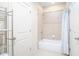 Cozy bathroom featuring a bathtub, neutral tiling, and storage shelving at 585 Lawton Bridge Sw Rd, Smyrna, GA 30082