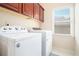Convenient laundry room with modern washer and dryer, cabinets for storage, and natural light at 585 Lawton Bridge Sw Rd, Smyrna, GA 30082