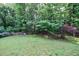 Large grassy backyard with a wooden fence and mature trees at 6455 Ivey Meadow Ln, Cumming, GA 30040
