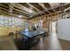 Unfinished basement with wood flooring, ping pong table, and access to a bathroom at 6455 Ivey Meadow Ln, Cumming, GA 30040