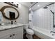 Well-lit bathroom with a subway tiled shower, white vanity, and a circular wood-framed mirror at 6455 Ivey Meadow Ln, Cumming, GA 30040