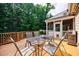 Deck with table and chairs, offers a delightful spot for outdoor meals and gatherings, with a grill nearby at 6455 Ivey Meadow Ln, Cumming, GA 30040