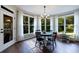 Sunlit dining area with large windows offering picturesque views and a charming chandelier at 6455 Ivey Meadow Ln, Cumming, GA 30040