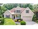 Inviting two-story home with manicured landscaping, attached two car garage, and charming front porch at 6455 Ivey Meadow Ln, Cumming, GA 30040