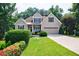 Charming two-story home with a manicured lawn, lush landscaping, and a two-car garage at 6455 Ivey Meadow Ln, Cumming, GA 30040