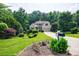Charming home featuring lush lawn, mature trees, and a neatly manicured garden enhancing curb appeal at 6455 Ivey Meadow Ln, Cumming, GA 30040