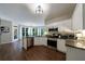 Modern kitchen with stainless steel appliances, granite countertops, white cabinets, and an eat-in area at 6455 Ivey Meadow Ln, Cumming, GA 30040