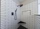 Close up of the shower with black fixtures and white subway tile with a corner seat at 6455 Ivey Meadow Ln, Cumming, GA 30040