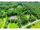Sprawling wooded property with mature trees, featuring a residence with a pool and outbuildings along a quiet road at 6919 Mount Zion Rd, Waco, GA 30182