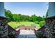 Backyard featuring a brick patio, lush lawn, and wooded border at 6919 Mount Zion Rd, Waco, GA 30182