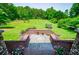 Backyard featuring a brick patio, lush lawn, and wooded border at 6919 Mount Zion Rd, Waco, GA 30182