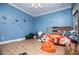Blue bedroom with ceiling fan and sports themed wall at 6919 Mount Zion Rd, Waco, GA 30182