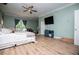 Bright bedroom featuring laminate floors, soft green walls, and views to the outdoors at 6919 Mount Zion Rd, Waco, GA 30182