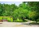 Lush front yard featuring mature trees and a circular driveway leading to a well-maintained home at 6919 Mount Zion Rd, Waco, GA 30182