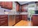 The kitchen is complete with stainless steel appliances, wood cabinets and hardwood flooring at 6919 Mount Zion Rd, Waco, GA 30182
