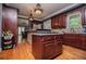 A kitchen featuring wood cabinets, stainless appliances, stone accents and hardwood floors at 6919 Mount Zion Rd, Waco, GA 30182