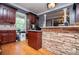 Cozy kitchen with custom cabinets, stone accent wall and hardwood floors at 6919 Mount Zion Rd, Waco, GA 30182
