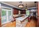 An eat-in kitchen with stainless steel appliances, wood cabinets, and a stone-clad breakfast bar at 6919 Mount Zion Rd, Waco, GA 30182