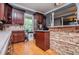 Cozy kitchen with custom cabinets, stone accent wall and hardwood floors at 6919 Mount Zion Rd, Waco, GA 30182