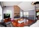 Cozy living room with a stone fireplace, hardwood floors, and staircase access at 6919 Mount Zion Rd, Waco, GA 30182