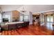 Open-concept living room featuring a stone fireplace, hardwood floors, and seamless flow to the kitchen at 6919 Mount Zion Rd, Waco, GA 30182