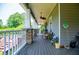 Over-sized porch featuring stone pillars, wood flooring and ceiling fans at 6919 Mount Zion Rd, Waco, GA 30182
