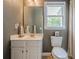 Cozy bathroom with a white sink vanity, toilet, neutral paint, and a window with outside views at 113 Gold Bridge Xing, Canton, GA 30114