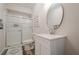 This is a bathroom with a walk-in shower and a white vanity and round mirror at 113 Gold Bridge Xing, Canton, GA 30114